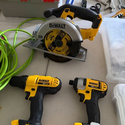 Sale Photo Thumbnail #90: DeWalt 20V Max cordless power tool set, including a 6 1/2-inch circular saw, a drill driver, and an impact driver, shown with hand tools and extension cord.