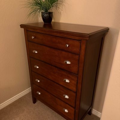 Sale Photo Thumbnail #136: Contemporary dark wood five-drawer chest with brushed metal bin pulls, topped with a potted faux plant.