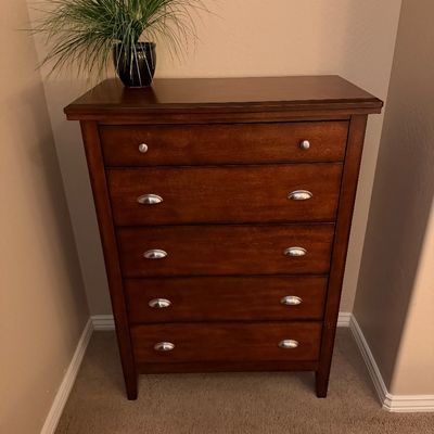 Sale Photo Thumbnail #123: Traditional five-drawer wood dresser in a warm cherry finish with brushed metal cup handles and knobs.