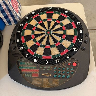 Sale Photo Thumbnail #101: Halex electronic soft-tip dartboard with digital score display and multiple game modes, set in a black plastic housing.