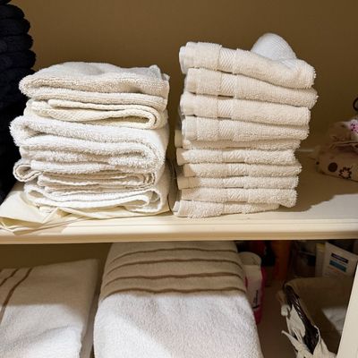 Sale Photo Thumbnail #154: Neatly folded stacks of white bath towels, hand towels, and washcloths arranged on closet shelving.