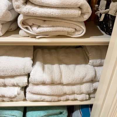 Sale Photo Thumbnail #142: Linen closet filled with neatly folded bath towels, hand towels, and washcloths in various shades including white, cream, and turquoise.