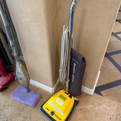 Sale Photo Thumbnail #157: Vintage Eureka High Filtration Commercial upright vacuum cleaner in yellow, featuring a heavy-duty fabric bag and chrome handle.