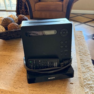 Sale Photo Thumbnail #47: Black Sony compact audio system component featuring a top-loading disc player, digital display screen, controls, and matching remote control.