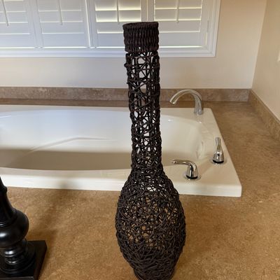 Sale Photo Thumbnail #8: Tall dark brown woven rattan floor vase with a open-work lattice design and a narrow neck.