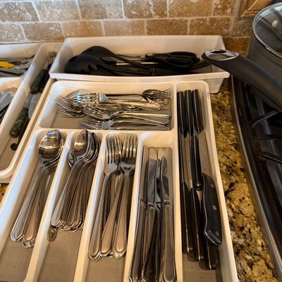 Sale Photo Thumbnail #173: White plastic drawer organizer filled with stainless steel flatware, steak knives, and kitchen utensils.