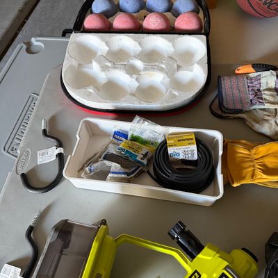Sale Photo Thumbnail #72: Collection of household and garage items, including a Ryobi ONE+ EZClean power cleaner, a bocce ball set in a case, gardening gloves, and irrigation supplies.