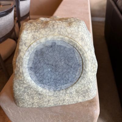 Sale Photo Thumbnail #57: Outdoor rock-style speaker featuring a faux-stone casing and a circular metal mesh grille.