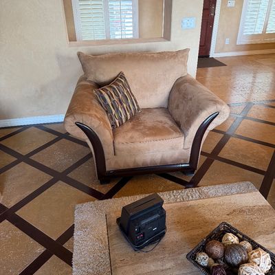 Sale Photo Thumbnail #30: Oversized tan microfiber armchair featuring dark wood trim accents and a patterned accent pillow.