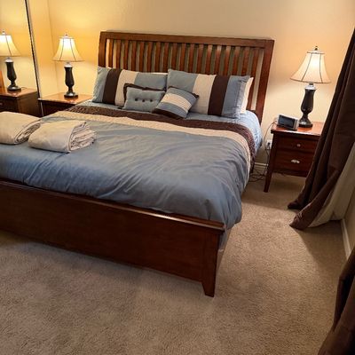 Sale Photo Thumbnail #132: Contemporary dark wood king-size slat bed frame set with matching nightstands and traditional table lamps.