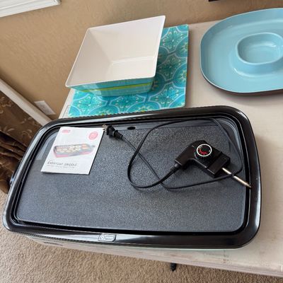 Sale Photo Thumbnail #200: Dash Everyday Griddle with non-stick surface, detachable power cord, and original instruction manual, shown alongside decorative serving bowls.