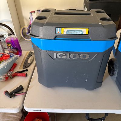 Sale Photo Thumbnail #99: Large Igloo insulated cooler with molded cup holders on the lid, sitting on a folding table alongside car wash supplies.