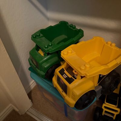Sale Photo Thumbnail #62: Collection of oversized plastic toy construction vehicles, including John Deere and CAT branded dump trucks.