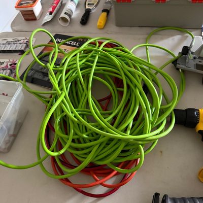 Sale Photo Thumbnail #77: Assorted heavy-duty extension cords, including bright green and red lengths, displayed alongside various hand tools and hardware accessories.