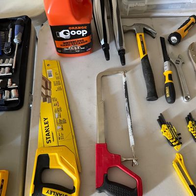 Sale Photo Thumbnail #79: Assortment of hand tools and workshop supplies, including a Stanley handsaw, hacksaw, claw hammer, wrenches, hex key sets, and a jug of Orange Goop hand cleaner.