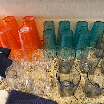 Sale Photo Thumbnail #159: Collection of colorful plastic drinking tumblers, including orange and teal textured cups alongside smoke gray and clear stemless glasses.