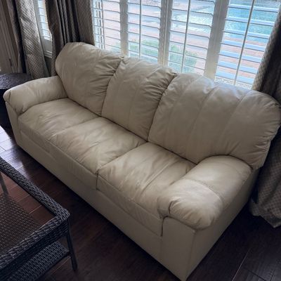 Sale Photo Thumbnail #11: Off-white or cream leather three-cushion sofa featuring pillow-top armrests and vertical seam detailing on the back cushions.