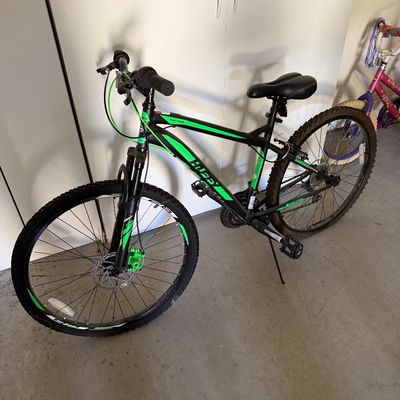 Sale Photo Thumbnail #107: Hyper Hydro 29-inch hardtail mountain bike in black with neon green accents, equipped with front suspension and front disc brake.