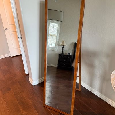Sale Photo Thumbnail #12: Full-length floor mirror with a warm wood frame in good condition.