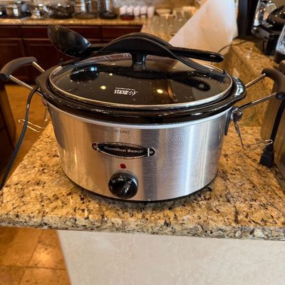 Sale Photo Thumbnail #187: Hamilton Beach Stay or Go slow cooker in brushed stainless steel finish, complete with locking glass lid and black serving utensil.