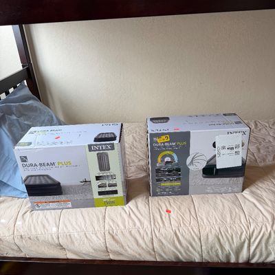 Sale Photo Thumbnail #3: Two boxed Intex Dura-Beam Plus inflatable air mattresses resting on a bed.