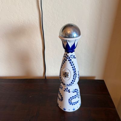 Sale Photo Thumbnail #27: Hand-painted Clase Azul Reposado tequila ceramic bottle featuring traditional blue cobalt feather motifs and a dome-shaped metal stopper.