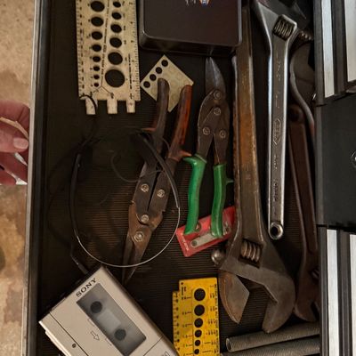 Sale Photo Thumbnail #154: Toolbox drawer filled with assorted hand tools, including large adjustable wrenches, tin snips, thread gauges, a Fossil watch tin, and a vintage Sony Walkman F1 cassette player.