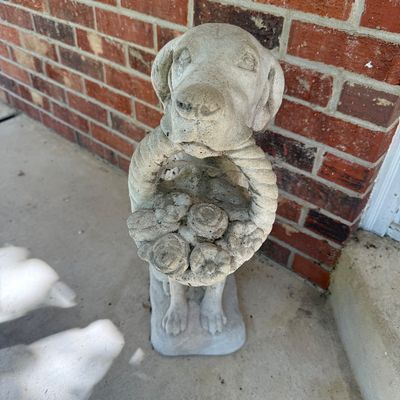 Sale Photo Thumbnail #81: Cast concrete garden statue of a dog holding a flower basket in its mouth, featuring weathered outdoor patina.