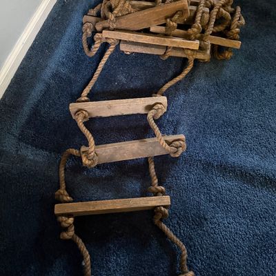 Sale Photo Thumbnail #113: Vintage flexible rope ladder with wooden rungs, showing light wear.