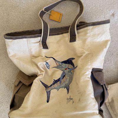 Sale Photo Thumbnail #111: Guy Harvey embroidered canvas tote bag featuring a marlin artwork, contrast brown handles and side flap pockets.