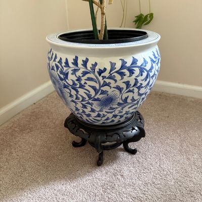 Sale Photo Thumbnail #32: Chinese blue and white porcelain fishbowl planter with floral vine patterns, set on a dark carved wooden stand.