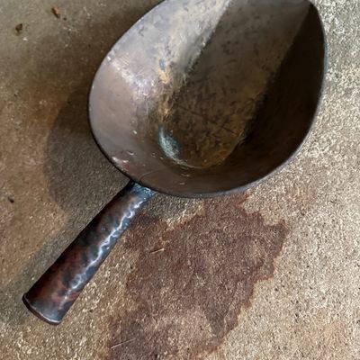 Sale Photo Thumbnail #62: Antique hand-hammered copper or brass scoop with a tubular handle and heavy patina.