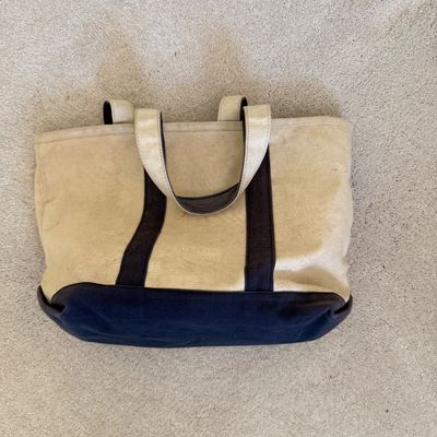 Sale Photo Thumbnail #112: Heavy-duty L.L. Bean canvas boat tote in cream with dark navy blue trim and base, showing light surface wear and discoloration.