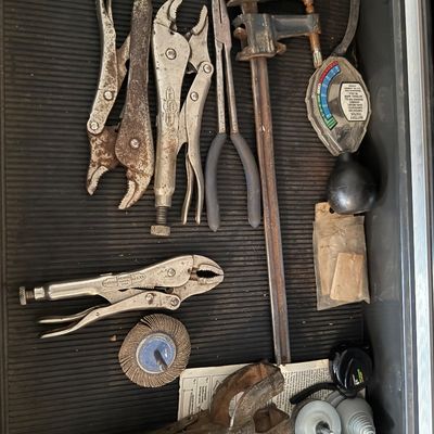 Sale Photo Thumbnail #142: Assortment of hand tools arranged in a drawer, including multiple Vise-Grip locking pliers, long needle-nose pliers, a bar clamp, and a battery tester.