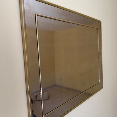 Sale Photo Thumbnail #21: Large vintage wall mirror with a gold-tone metal frame and tinted mirrored border, late 20th century.