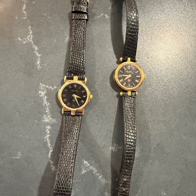 Sale Photo Thumbnail #5: Pair of vintage Gucci women's wristwatches with gold-tone round cases, black Roman numeral dials, and black lizard-embossed leather straps.