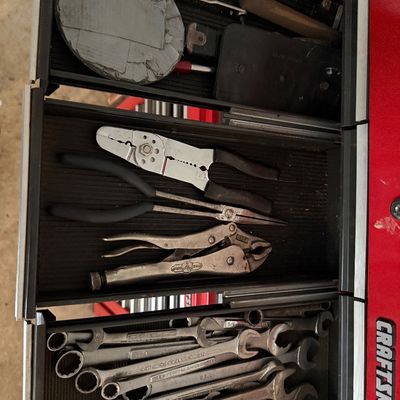 Sale Photo Thumbnail #138: Red Craftsman tool chest filled with an assortment of hand tools, including combination wrenches, Vise-Grip pliers, wire strippers, and screwdrivers.