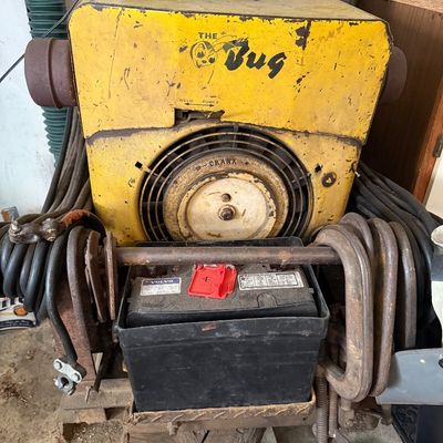 Sale Photo Thumbnail #157: Vintage yellow "The Bug" portable welder generator unit with attached cables, battery, and C-clamps.