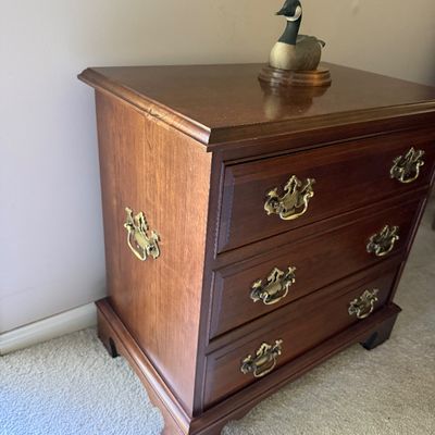 Sale Photo Thumbnail #47: Traditional cherry-stained wood three-drawer nightstand with brass batwing hardware and side carrying handles,