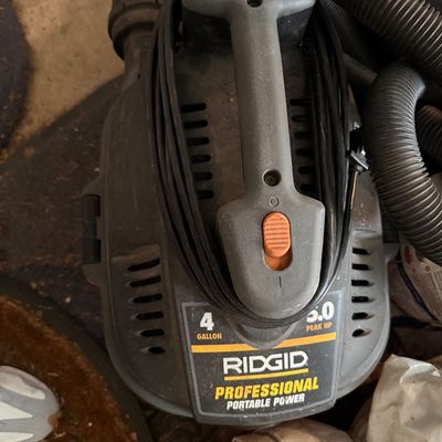 Sale Photo Thumbnail #165: Ridgid Professional Portable Power 4-gallon wet/dry vacuum with a 5.0 peak HP motor, wrapped cord, and attached hose.