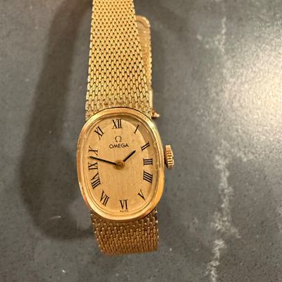 Sale Photo Thumbnail #3: Vintage Omega ladies' wristwatch featuring a gold-tone oval case, Roman numeral dial, and an integrated woven mesh strap.