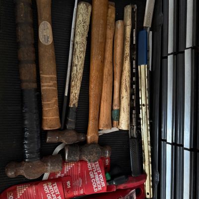 Sale Photo Thumbnail #140: Collection of vintage hand tools including wooden-handled ball-peen hammers, punch tools, socket organizers, and anti-freeze testers arranged inside a toolbox drawer.