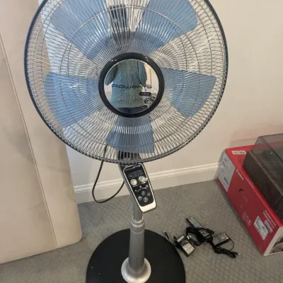 Rowenta Turbo Silence Extreme standing pedestal fan with blue blades, control panel, and power accessories.