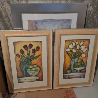Matching pair of framed floral still life art prints featuring tulips and fruit in complementary peach-toned wood frames.