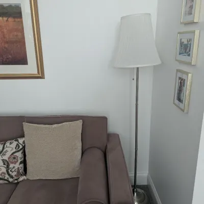 Brushed nickel metal floor lamp with a pleated white shade