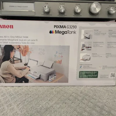Canon PIXMA G3290 MegaTank wireless all-in-one printer in its original retail box, sitting below a vintage silver-face stereo 8-track...