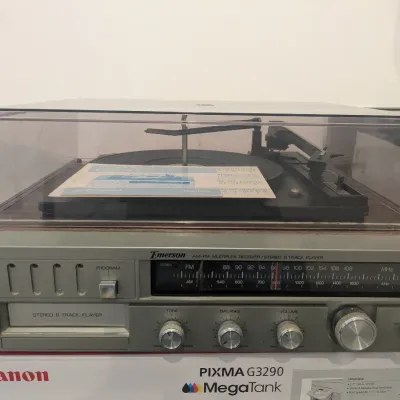 Vintage Emerson AM-FM multiplex receiver stereo system featuring an integrated 8-track player and top turntable with a clear dust cover.