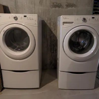 Pair of white Whirlpool Duet front-load washer and dryer units, each mounted on a matching pedestal drawer. Originally purchased in 2014.