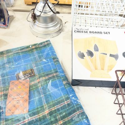 Sale Photo Thumbnail #94: Selection of household items including a new-in-packaging Patrick King merino wool pocket scarf in blue plaid and a Medieval cheese board set in its original box.