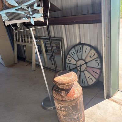 Sale Photo Thumbnail #72: Collection of home decor items including a vintage rusty metal milk can, a large oversized wall clock, a floor lamp, and a decorative birdcage stand.